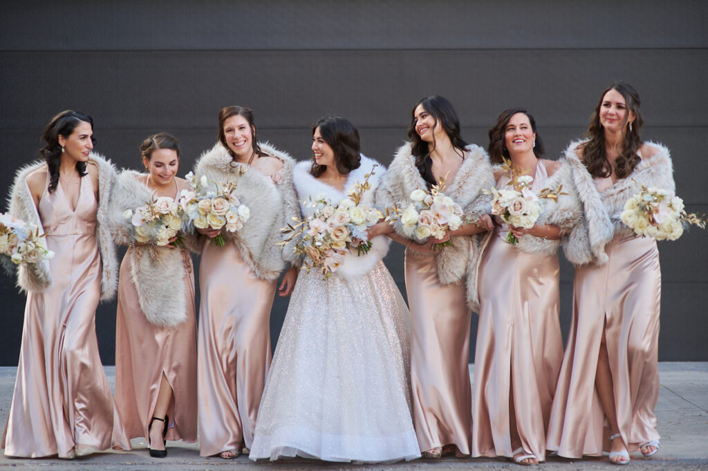 bridal party in satin champagne bridesmaid dresses walking in downtown Minneapolis