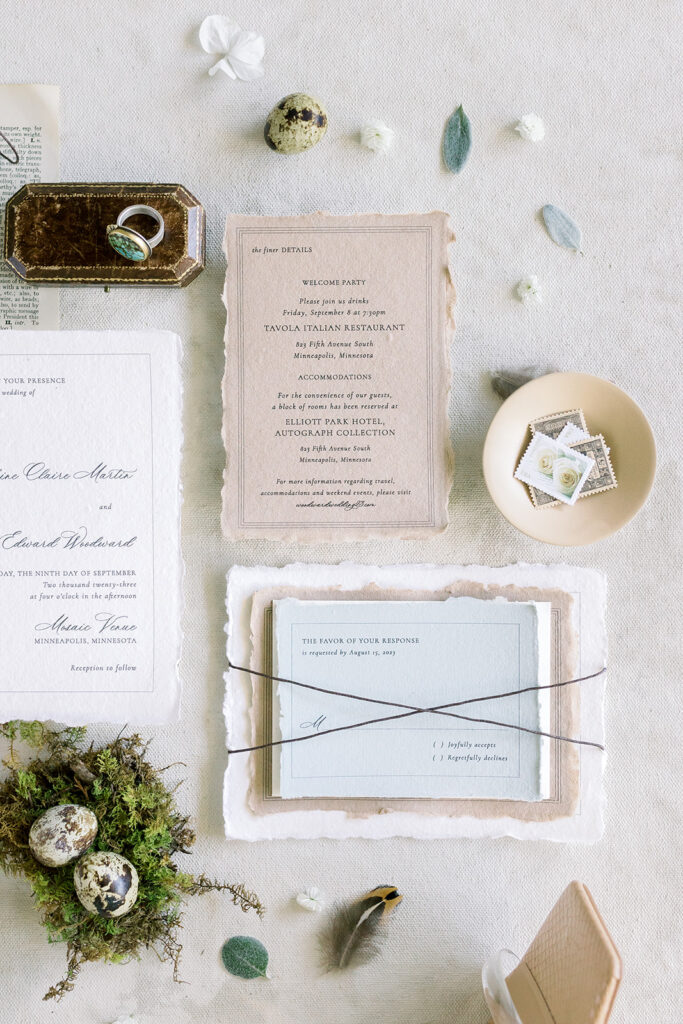 beautifully designed wedding invitation suite featuring quail eggs, stamps, and a turquoise ring